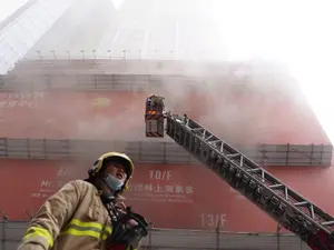 Pompierii încearcă să evazueze oamenii din turn. FOTO: South China Post