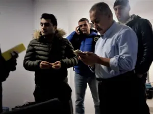 Kamil Demirkaya, în stânga imaginii, cu un telefon în mână Foto: zaman România