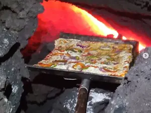 Fluxul de lavă incandescentă se mişcă lent, iar căldura rocilor găteşte ''Pizza Pacaya'', denumită astfel după vulcanul din sudul statului Guatemala. / Foto: agerpres.ro