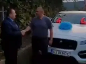 Unchiul Morega, PNL, îl felicită pe nepoțelul Morega, PSD. La mijloc, un Jaguar, neutru. Foto: Captură video