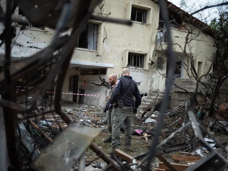 Ofițeri de securitate israelieni inspectează o zonă lovită de o rachetă trasă de Hezbollah Foto: Profimediaimages.ro