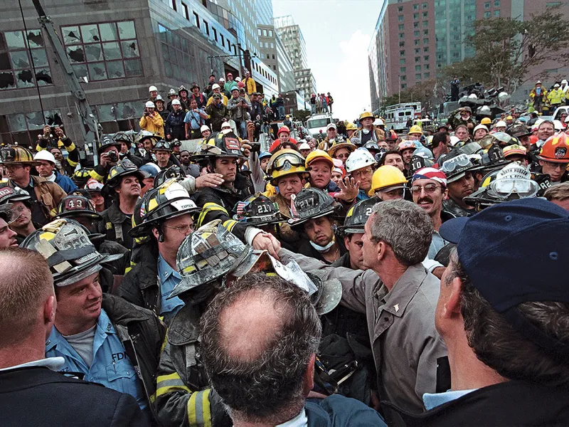 Bush salută pompierii, poliția și salvatorii în timp ce se deplasează prin ce a mai rămas din WTC, la trei zile după atacuri.