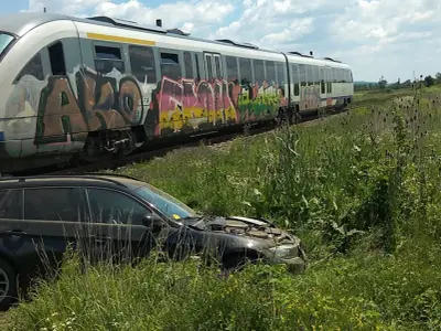 Pasagerii unui autoturism au scăpat ca prin minune după ce mașina le-a fost spulberată de un tren/ sursa: incomod-media.ro