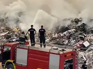 Pompierii luptă să stingă incendiul din groapa de gunoi. FOTO: Captură video