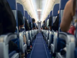 Motivul pentru care o pasageră a fost dată afară din avion. Se juca pe telefon când a venit poliția - Foto: Istock / imagine cu rol ilustrativ