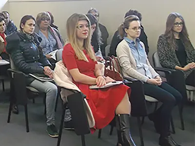 Tânăra femeie în rochie roșie  și vecina din stânga ei au participat în două proiecte diferite ale aceluiași beneficiar