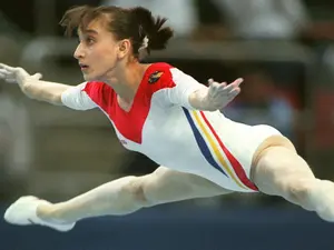 Gina Gogean, fosta mare gimnastă română, evoluând la bârnă, în septembrie 1997 - Foto: Profimedia Images