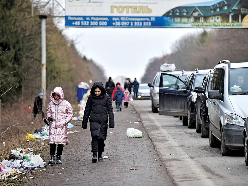 Copiii merg alături de un șir de mașini lung de 19 kilometri care așteaptă să treacă granița dintre Ucraina și Polonia / newsweek