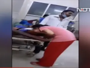 O fiică îi face respirație gură la gură mamei bolnave de COVID pe holul unui spital din India Foto: captură video Youtube