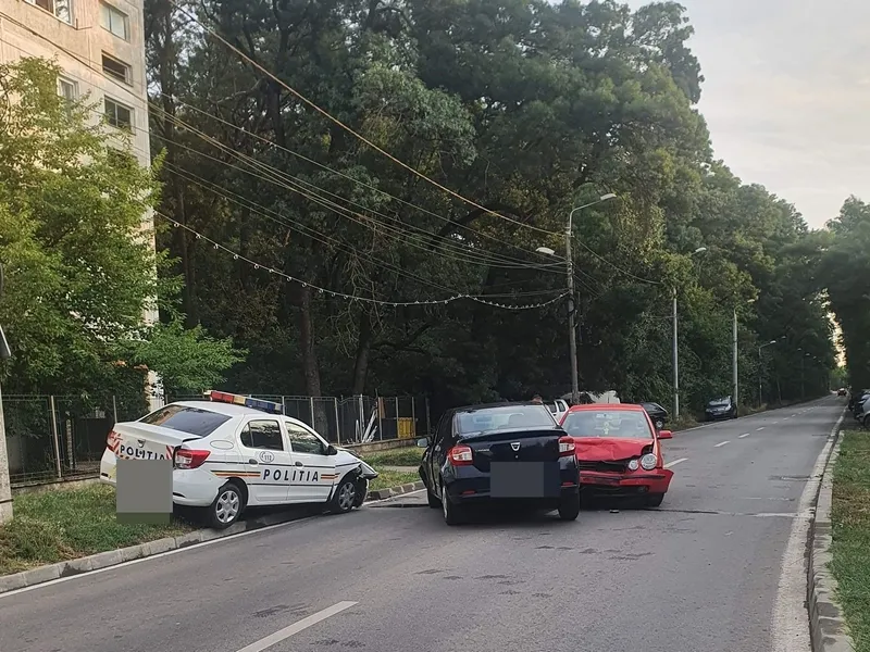 Două mașini de poliție parcate pe stradă, pe contrasens, lovite de o șoferiță „talentată”. / Foto: tion.ro